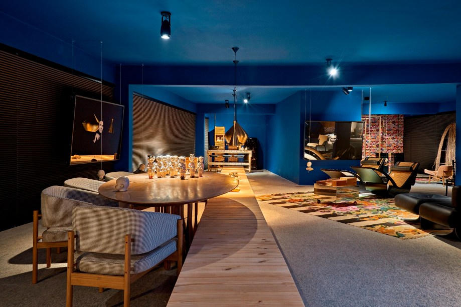 Casa Leo - Leo Romano. Paredes e teto cobertos de um azul anil intenso conferem o clima de sonho, mistério e dramaticidade nestes 200 m², divididos em pequenos ambientes. Os layouts são determinados por peças de Oscar, Irmãos Campana, Jean Gillon, Etel Carmona, Dado Castelo Branco, Isay Weinfield e do próprio Leo. Em cada um, retratos do profissional - feitos pela fotógrafa Maria Célia Siqueira - emergem de uma imensidão de preto.