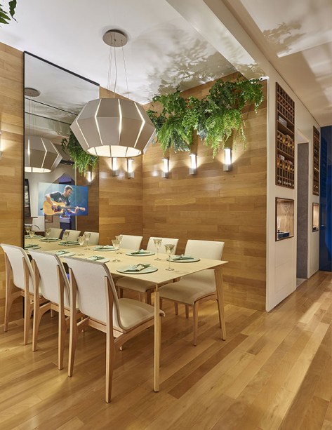Sala de jantar e adega: Laura Santos. A madeira enobrece o espaço, seja no buffet de Pau Ferro, na mesa em Carvalho e madeira Patinada, na adega com detalhes de Nogueira ou no piso de Peroba Dourada. A opção por duas adegas automatizadas agrada ao cliente que deseja setorizar seu acervo por países, uvas ou safras.