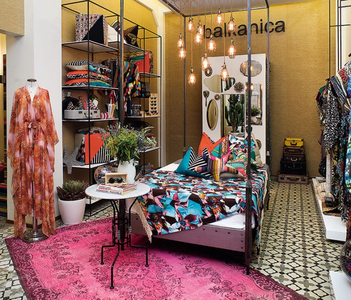 CASACOR Peru 2015. Boutique de design - Mariana Albarrán e Delia Rodriguez. Um ambiente escultural, moderno, cálido. A cama protagoniza no centro do espaço e contracena com luminárias de design, além de permitir uma exposição mais atrativa de tecidos e almofadas. A cartela de cores é intensa, com pinceladas de pink e mostarda. Ferro, madeira e ráfia são as principais matérias-primas do projeto, que também combina itens novos e reciclados.
