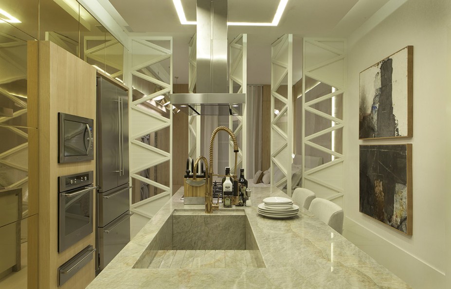 Loft Contemporâneo - Sérgio Caus. A marcenaria bem desenhada é o ponto de partida do espaço concebido para um casal de médicos. Aplicações de espelhos e ACM valorizam as divisórias pivotantes na cozinha, que ganha ainda mais requinte com os acabamentos em dourado.