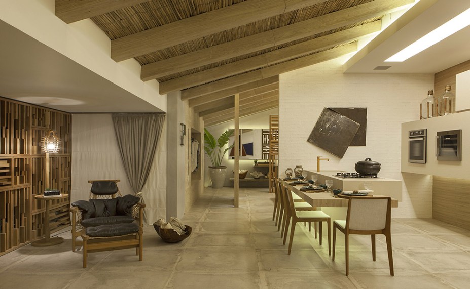 Casa da Praia - Letícia Finamore. A casa é para um jovem casal apaixonado por sol, praias e natureza. Para um ar simples e casual, a arquiteta definiu uma planta integrada e adotou cores claras que iluminam o espaço, onde também predomina o tom de cimento queimado no piso. Algumas paredes foram aquecidas com tijolinhos, e a madeira freijó lavada surge pontualmente nos móveis. Outras texturas naturais que se completam são o linho, a palha no teto e o mármore travetino rústico na bancada da cozinha.