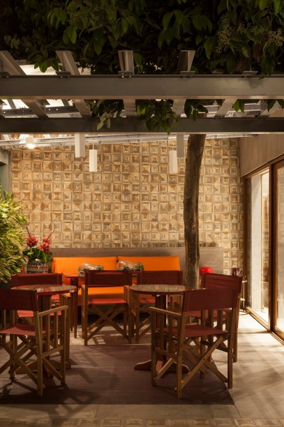 <span>Empório - Alexandre Mesquita e Neto Belém. A dupla criou uma arquitetura efêmera no jardim, com estrutura metálica e esquadrias em PVC. Este pergolado abraça a árvore e reúne mesas do designer Fernando Diraiz, acompanhadas de cadeiras modelo diretor, da Domodi. Internamente, o espaço conta com uma cozinha de apoio.</span>