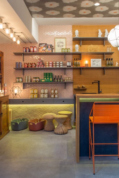 <span>Mercearia da Casa - Paula Neder e Luiza Pedral. No teto foi aplicado um dos tecidos desenvolvidos em parceria com a La Estampa e o Espaço Multi, especialmente para o projeto. Na parede diante da entrada, pastilhas sextavadas em rosa convivem com outros revestimentos e destacam as prateleiras com produtos à venda.</span>