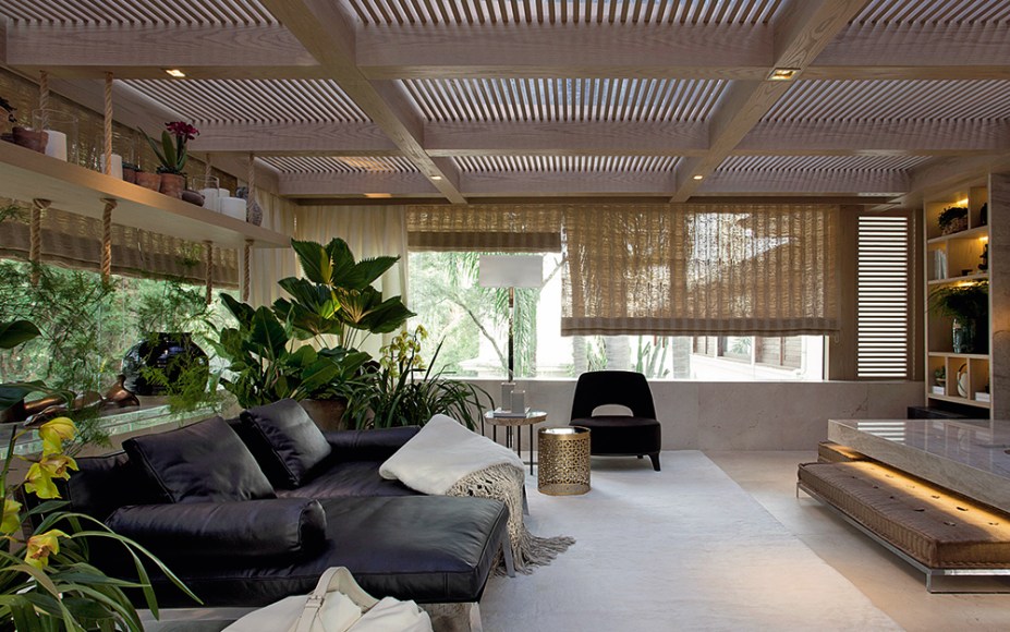 <span>CASACOR São Paulo 2016. Jardim Suspenso - Andrea Teixeira e Fernanda Negrelli. O espaço traz o conforto sugerido pela marcenaria de carvalho americano e pela lareira centralizada no espaço. O dourado fosco e os tons neutros, como no piso em mármore crema marfil com acabamento opaco, formam a base da cartela de cores. A única (e bem-vinda) interferência são as plantas nativas e orquídeas do paisagismo de Leda Jafet.</span>