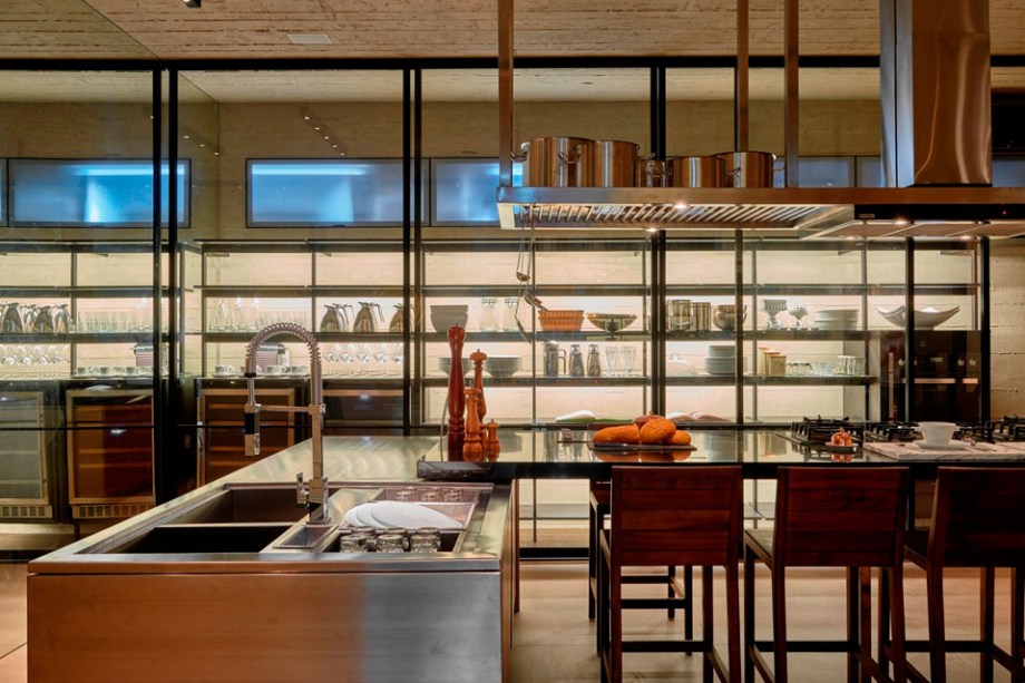CASACOR Brasília - Cozinha. Priscila Gabriel otimizou o espaço de 31 m² com uma parede cênica de fundo, que concentra despensa, louceiro e eletrodomésticos no mesmo plano. Outro ponto importante foi a ideia de soltar todas as bancadas da parede e resumí-las em ilhas sobrepostas. Concreto e metal predominam, transmitindo uma atmosfera industrial.