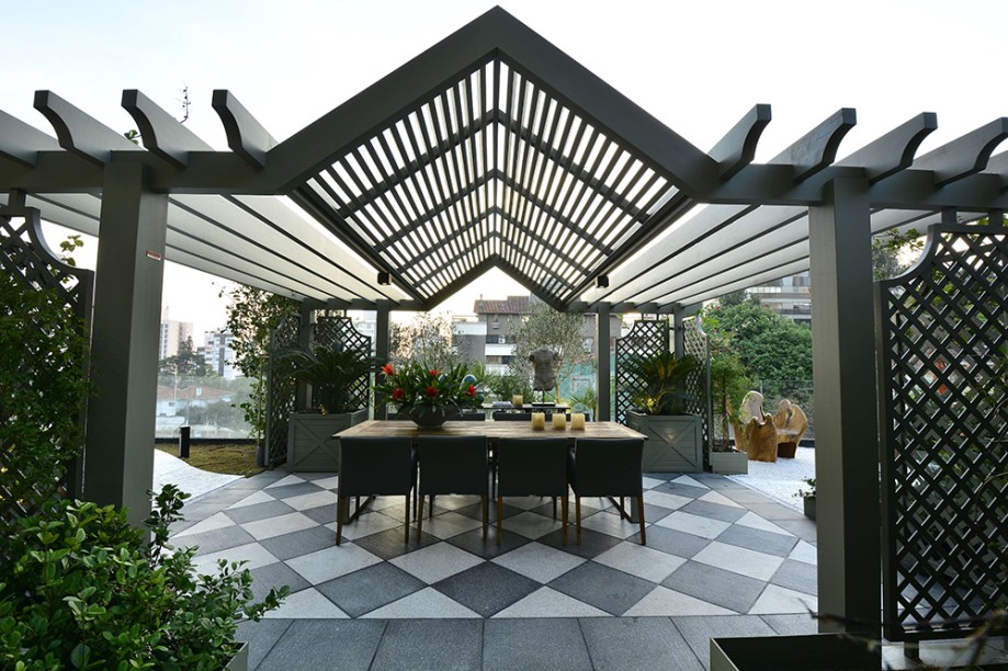 <span>CASACOR Rio Grande do Sul 2016. English Garden - Fernando Thunm. O jardim inglês tradicionalmente rompe com a simetria e linearidade dos jardins franceses e italianos. Nele, Fernando adicionou pontos de interesse como fontes e o gazebo, com treliças de madeira na cor verde antigo. O ambiente abriga a mesa de refeições com um grande aparador, sobre o piso xadrez.</span>
