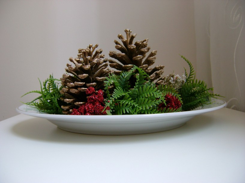 Flores, pinhas e velas são ótimas para arranjos de mesa. Se você pretende sair um pouco dos clássicos verde e vermelho, opte pelo branco, prata e dourado, que imprimem elegância à mesa.