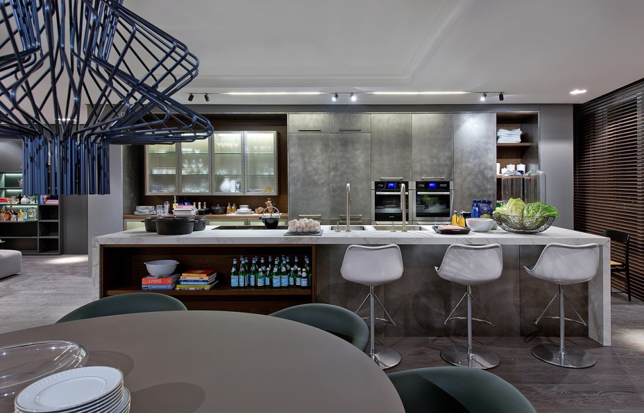 Estar Gourmet - Tufi Mousse. O espaço de 110 m² é palco de encontros gastronômicos e a sua premissa é ser funcional e receptível, já que é de fato um ambiente usual. Para este projeto, o profissional se inspirou nas indústrias e antigas casas com cozinhas azulejadas. A atmosfera industrial percorre as cores e revestimentos do local, marcado pelos tons de cinza, em sua maioria, com pitadas de calor da madeira e dos tons de azul e verde em objetos que compões o décor do estar.