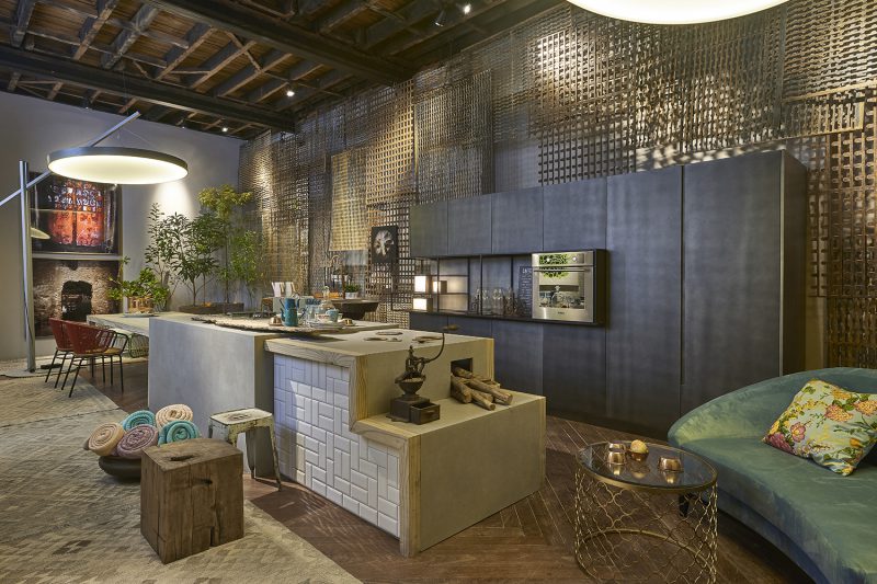 Cozinha de Quintal - Ana Paula Rohfs. <em></em>A profissional se inspirou no conceito de cozinha de fazendas antigas e na história centenária do casarão para desenhar móveis para o espaço. Ana buscou traduzir essa história para a realidade mas com uma pegada contemporânea. Assim, ela trouxe para o espaço uma releitura do <strong>fogão a lenha</strong>, em uma versão prática, supermoderna e feita em neolit resistente a altas temperaturas. Outra ideia foi trazer a atmosfera de um ambiente “externo” para o “interno”, para isso Ana Paula criou <strong>luminárias </strong>que lembram ombrelones. Nesse processo, a <em>Abatjour de Arte</em> ajudou na concepção da peça de grandes proporções e luz suave.