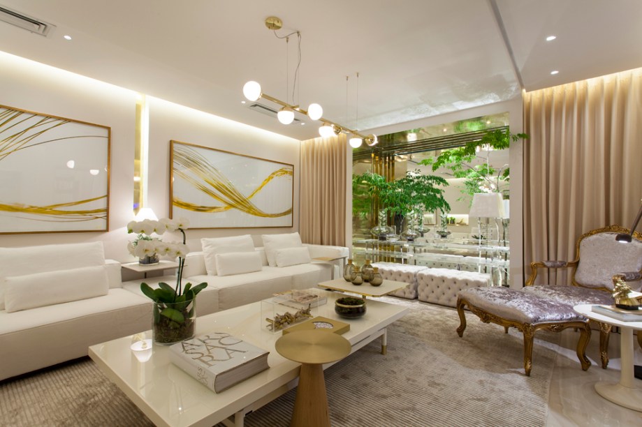 Sala Ouro Fino - Aline Cangussú. Com referências da cidade histórica de Ouro Fino, o ambiente resgata o costume mineiro de receber bem os convidados. Elegante, sofisticada e acolhedora, a sala mistura os estilos clássico e contemporâneo. Destaque para o aparador de acrílico e as esculturas de Evannez Phyton e Tati Moreno.