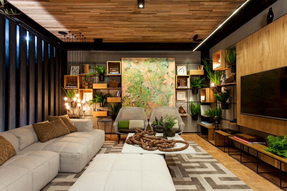 <span>Estar do Jardim - Laís Galvão. O ambiente agrega o design internacional com o brasileiro e valoriza a arte e a cultura local com muita elegância e conforto. Com iluminação natural da medida, o verde foi explorado através das plantas distribuídas nos nichos da estante que envolve a sala.</span>