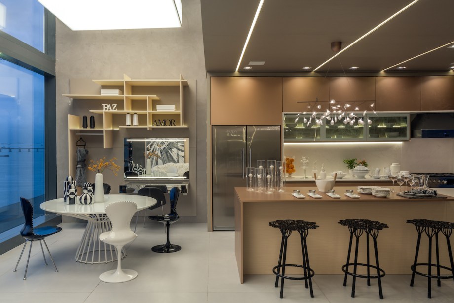 CASACOR Rio de Janeiro 2017. Cozinha Gourmet da Estilista – Cristina Côrtes. Esse espaço foi projetado para ser não só uma cozinha, mas também um espaço corporativo. Com 64 m², ela foi criada para a profissional de moda que deseja receber seus clientes em casa. Todo o ambiente foi revestido em painéis com acabamentos em laca metalizada e amadeirado, assinados pela estilista Glória Coelho. A ilha se destaca como área de contemplação e trabalho.