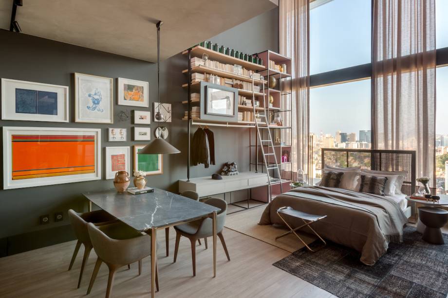 <span>Box 21 - Beta Arquitetura - Bernardo Gaudie-Ley e Tânia Braida. </span><span>A dupla de profissionais se inspirou nos lofts nova-iorquinos para criar o espaço ideal para um empresário paulista. Os tons de cinza e preto com toques de verde e rosa dão delicadeza e criam uma atmosfera cosmopolita. O pé direito alto abriga a estrutura de ferro que comporta uma estante e o closet.</span>