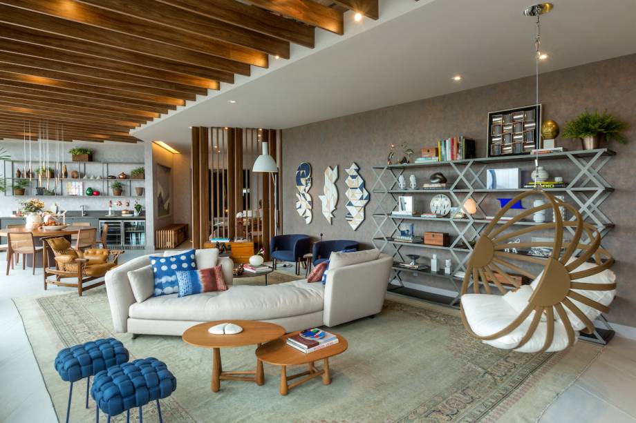 CASACOR RJ: No Espaço CoLab, Paula Neder e Luiz Fernando Grabowsky apostaram num sofá versátil: curvilíneo, que permite a interação entre os convidados, e com assentos de ambos os lados, abrindo espaço para dois ambientes — um estar com poltronas num clima mais intimista e outro com banquinhos e balanço, todo descontraído.