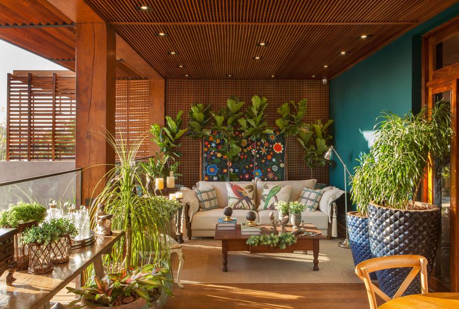 CASACOR Franca: Aqui é para sentar e apreciar a natureza, na Varanda Pôr do Sol, do escritório Galpão do Arquiteto. O sofá branco se destaca no meio do verde e dos tons de madeira, além de permitir uns minutinhos contemplando a vista e até uma pausa para a leitura ou um relax em meio a essa tranquilidade.