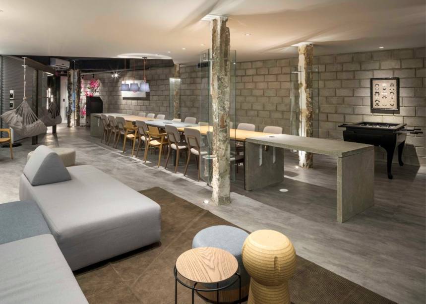 CASACOR Brasília. <span>Casacoworking - Rafaella Vieira, Alex Brasileiro, Luciana Lopes e Alexandre Rocha. Inspirados nos locais de trabalho colaborativos, os profissionais chegaram ao estilo industrial. Ele é bem representado em blocos de concreto aparente, reboco rústico, telas metálicas, eletrocalhas e pilares demolidos, abrigados em caixas de vidro. Sofás modulares, mesas lado a lado e pufes permitem reconfigurar o layout, enquanto balanços de rede convidam ao ócio criativo.</span>