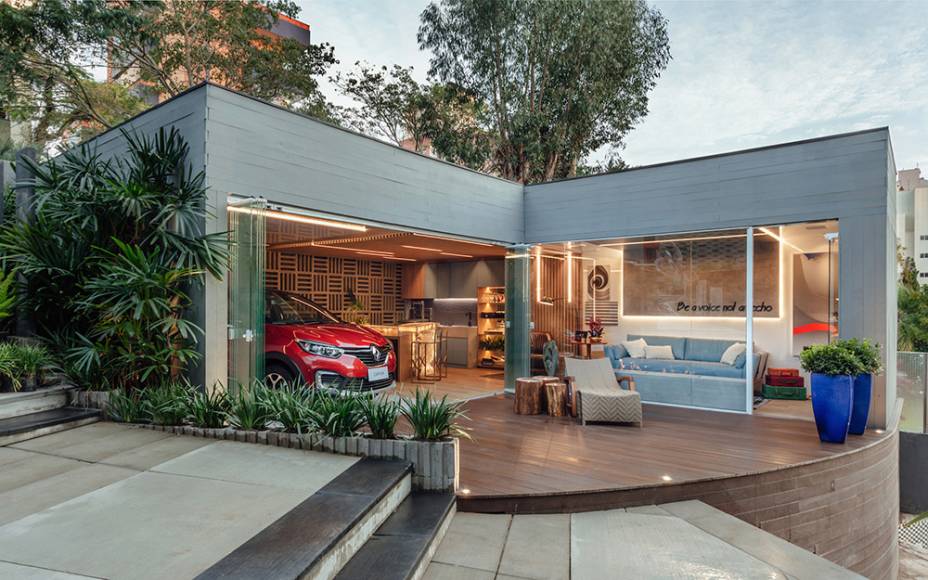 CASACOR Rio Grande do Sul. <span>Garagem de Estar Renault - Cristina Da Luz e Davi Alexandre Heissler. O espaço é único e integrado, com fachada em pele de vidro que permite visualizar o lounge gourmet e o estar. Para surpreender, a dupla aposta no delicado azul do sofá de Pedro Mendes, em detalhes dourados e no mármore iluminado da bancada. A iluminação é destaque e se infiltra nos ripados de MDF, um dos vários materiais sustentáveis utilizados no projeto.</span>