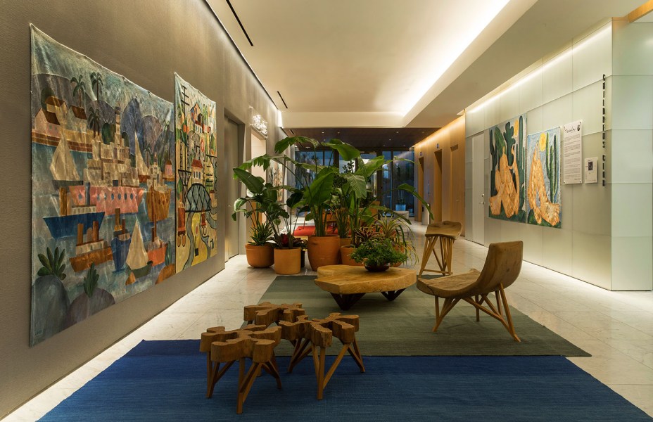 CASACOR Miami. Tarsila Hall copyright © Tarsila Empreendimentos - Paulo Alves Design. O lobby do elevador foi convertido em galeria de arte, com paredes que exibem tapeçarias inspiradas em pinturas famosas da modernista Tarsila do Amaral. Os tapetes de várias cores completam o décor.