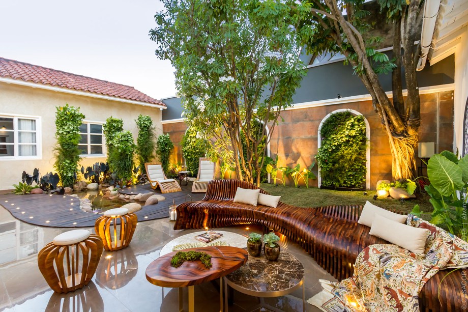 El Patio Viviente - Natalia Murillo, Giuseppe Di Domenico E Silvia Oliva. Um jardim vertical surge dos arcos da casa, junto com as colunas verdes. O cenário se completa com o pequeno lago, rodeado por um deck curvilíneo e um banco igualmente sinuoso. Aliás, ele foi produzido com mais de 120 peças de carvalho branco, com o conceito de fabricação digital.