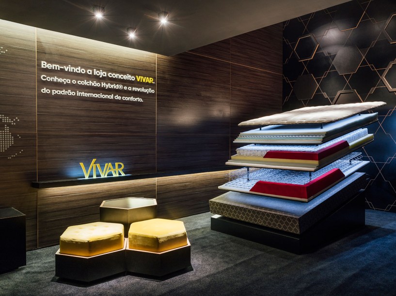 Loja Conceito Vivar - Criaforma Arquitetura. Com um quê minimalista e industrial, a proposta desconstrói os elementos que compõem os colchões, principais produtos da loja. As molas, por exemplo, compõem uma das divisórias do espaço. Além de tecnológico, o clima é intimista, com painéis em MDF escuro nas paredes e a luz cênica pontual.