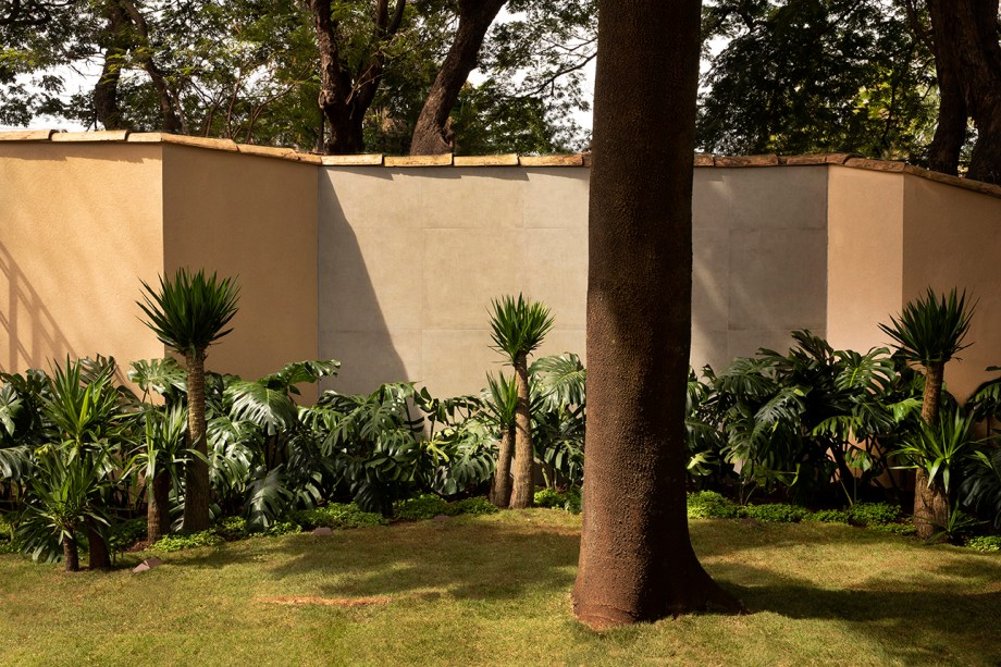 Jardim Lounge Saída - Marcelo Faria. O jardim de 200 m² guarda diversas espécies, como o ipê rosa e o baobá. Além da preservação das árvores originais, o paisagista agregou texturas tropicais com espécies mais baixas, como xanadu, costela de adão e fórmio. O gramado zeon dispensa manutenção constante e é ideal para o clima seco.