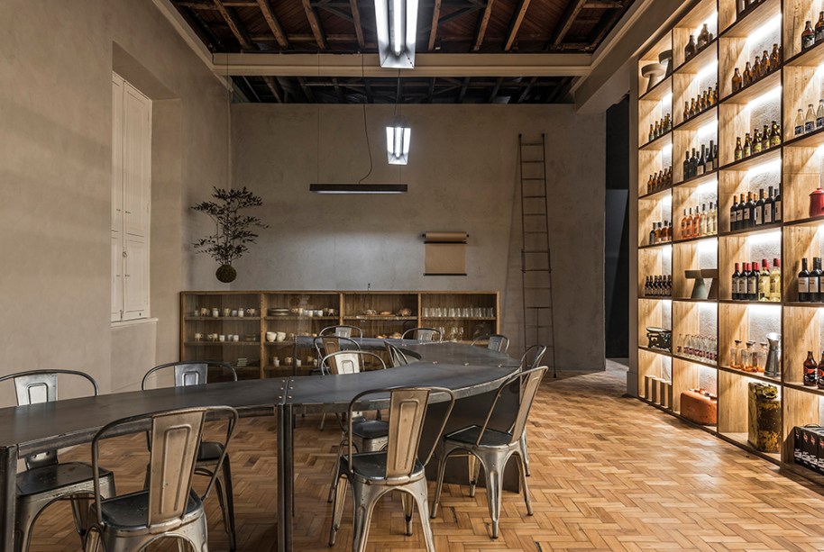 CASACOR Minas Gerais. Armazém CASACOR - Ø Arquitetos (Filipe Pederneiras, Thiago Bandeira e Katarina Grillo). Duas mesas em aço, com sistema modular, criam um percurso que estimula a convivência no ambiente, destinado à apreciação da gastronomia mineira. O aspecto industrial é reforçado nos tons de cinza das paredes, nas luminárias em aço e no mobiliário de apoio em mogno africano reflorestado, com design dos arquitetos.
