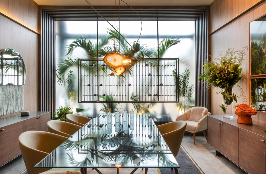 Sala de Jantar - Cirlene Reco. O ambiente de 41 m² traz um estilo natural urbano, mostrando que é possível conciliar os dois universos e ainda recuperar o hábito de conviver ao redor da mesa. Boa parte das peças foi desenhada pela profissional, como a adega com a cascata d’água, os aparadores de madeira e a mesa com inspiração nos pássaros.