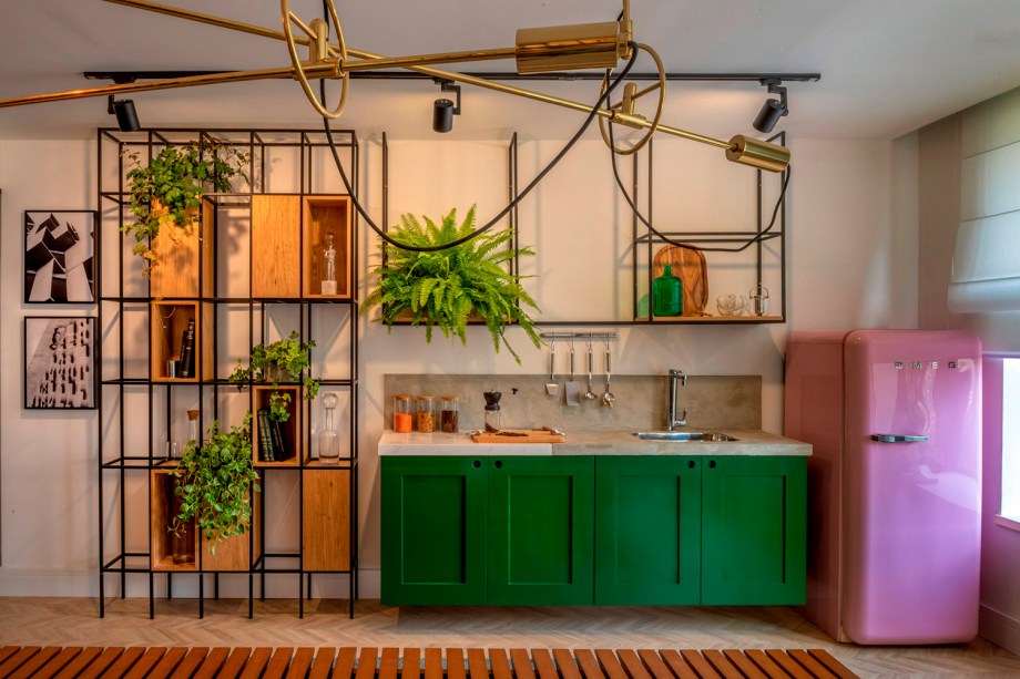 Camila Ramundo, Danilo Ferreira e Maria Carolina Valim utilizaram a criatividade para incorporar folhagens e outras plantas na Área de Convivência. Uma estante com nicho transforma-se em suporte para os vasos, que ficam junto dos livros e demais objetos decorativos.