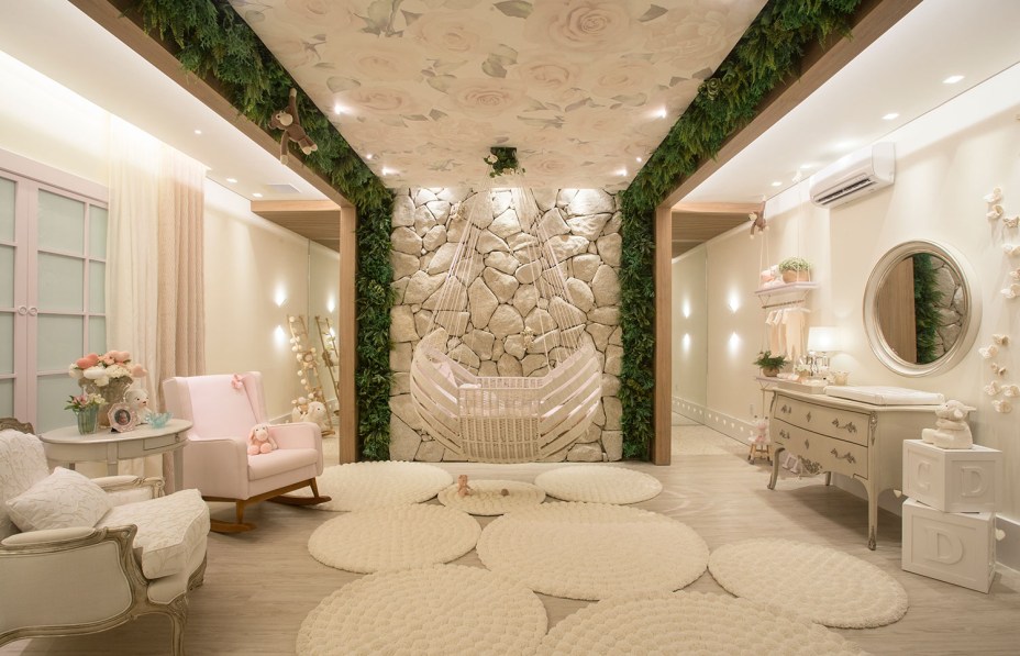 Suíte do Bebê - Luciana Duarte. Com 42 m², o projeto mistura materiais e tendências, como couro, madeira e pedra, fazendo um ambiente aconchegante para o bebê. O berço, desenhado pelo designer Sergio Matos, está suspenso e traduz a leveza do espaço. O quarto ainda têm um jardim vertical, decoração com pedras naturais, peças de corian iluminados e animais de crochê, tornando-o ainda mais lúdico e vivo. Tons claros e neutros marcam os móveis e paredes.
