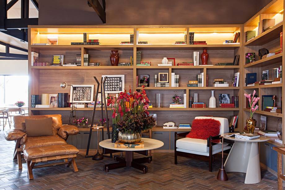 CASACOR São Paulo 2016. Restaurante do Jockey - Barbara Jalles. A marcenaria ganha destaque, planejando o espaço para destacar as memórias e os objetos logo na entrada do ambiente. Alguns nichos foram iluminados, direcionando o olhar.