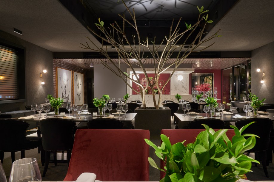 Restaurante – Ricardo Oliveira de Assis. Inspirado nos restaurantes franceses contemporâneos, o espaço de 117 m² destaca a presença do tom marsala em estofados e paredes. As plantas ficam em meio às mesas, para trazer a natureza para dentro do espaço. Piso, paredes e o teto da área das mesas são revestidos por carpete, gerando um conforto extra. A iluminação utiliza peças da designer Cristiana Bertolucci.