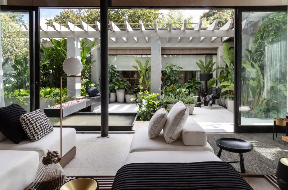 CASACOR São Paulo 2019. Casa Grão por Starbucks at Home - Très Arquitetura. Assinando, pela primeira vez, o projeto de uma residência completa na mostra, Fernanda Tegacini, Fernanda Morais e Nathalia Mouco, sócias da Très Arquitetura, guiaram-se pelo conceito do grão, que se define não só pelo nascimento do café, mas pelo princípio de profusas vidas, para desenvolver o ambiente de 100m.. Baseadas nas premissas de uma geração que busca por uma vida mais desprendida, altruísta e humanizada, as arquitetas também se inspiraram nas linhas do pavilhão de Mies Van Der Rohe, em Barcelona, e criaram um espaço em formato de caixa de vidro, que engloba living, sala de jantar com uma pequena cozinha, terraço e uma suíte master.
