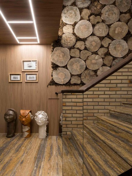 CASACOR Santa Catarina | Balneário Camboriú 2019. Sala Raízes - Geovani Capelina. Para expressar a valorização de origens familiares e culturais, o ambiente vai ao encontro de memórias afetivas, recuperando texturas, cores e formas acolhedoras. Os troncos em sua forma natural criam o impacto visual, junto com as obras de arte, convivendo com a iluminação delicada e materiais frágeis como espelhos.