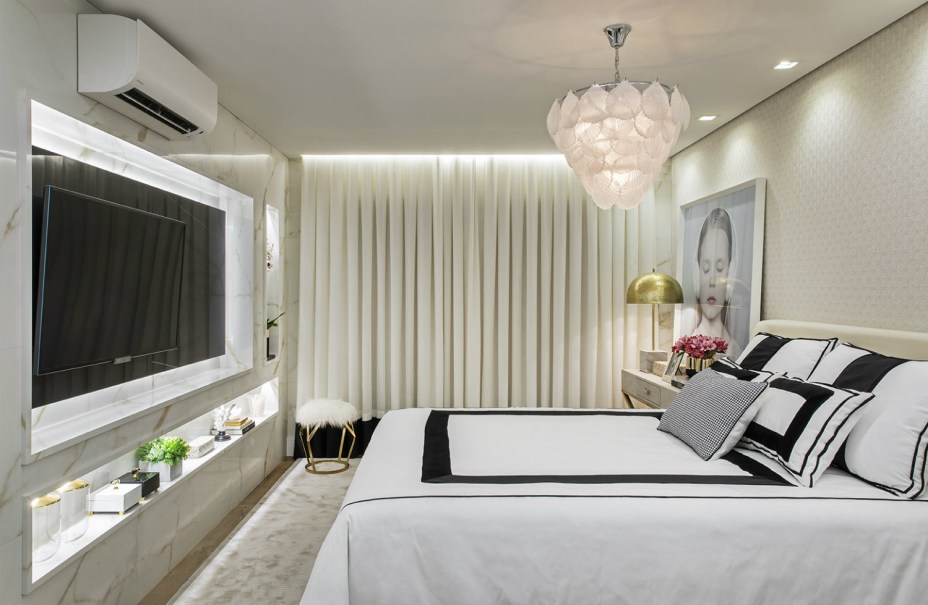 CASACOR Ribeirão Preto 2019. Rafael Granero - Quarto da Influencer. Com 19 m², o espaço atende ao jovem influencer que valoriza um ambiente dinâmico, moderno e até mesmo luxuoso. Não é mero acaso que a inspiração venha da marca Chanel, representada na cartela de preto, branco, bege, dourado e vermelho. A iluminação também tem peso fundamental, combinando LEDs nos nichos e no forro, alguns spots e um lustre Art Déco que rouba a cena.