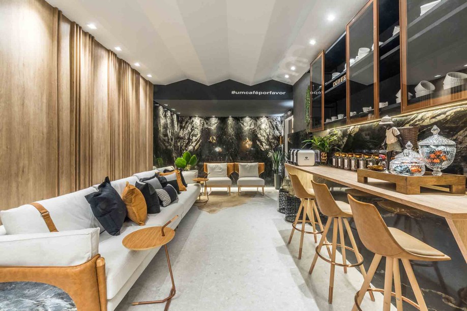 Paula Corrêa e Socorro Galvão - Living do Café. No período colonial, as salas de café eram espaços que prolongavam o bate-papo após um jantar entre amigos. O hábito é revivido neste projeto sob um olhar contemporâneo, que apresenta o contraste entre a madeira clara e a quietude de tons escuros, especialmente do mármore que reveste as paredes.