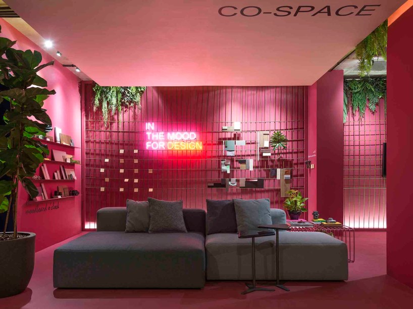 Co-Space para Arquitetos e Designers - Barbara Ramos e Maria Eduarda Brandão. O ambiente de trabalho e reuniões informais também atende aos momentos de descompressão. Instagramável, a caixa que envolve todo o espaço e cria unidade visual foi tingida de pink. O perfeito contrapondo é a cor verde, inserida por meio dos ficus, samambaias e jibóias que dão vida ao lugar. O sofá modular torna o ambiente versátil, na mesma pegada das prateleiras e da tela metálica que deixam as paredes mais funcionais.