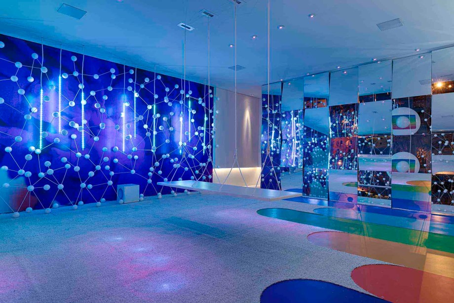 OBJ Design e Arquitetura - Espaço Globo. Luz e som protagonizam neste espaço cênico, em uma interação quase sinestésica e coreografada dos elementos, proporcionando várias propostas de intensidades e cores variadas. O ambiente foi projetado em branco, o que confere uma impressão tridimensional salientado pelos recortes do espelho, ampliando o leque de sensações.