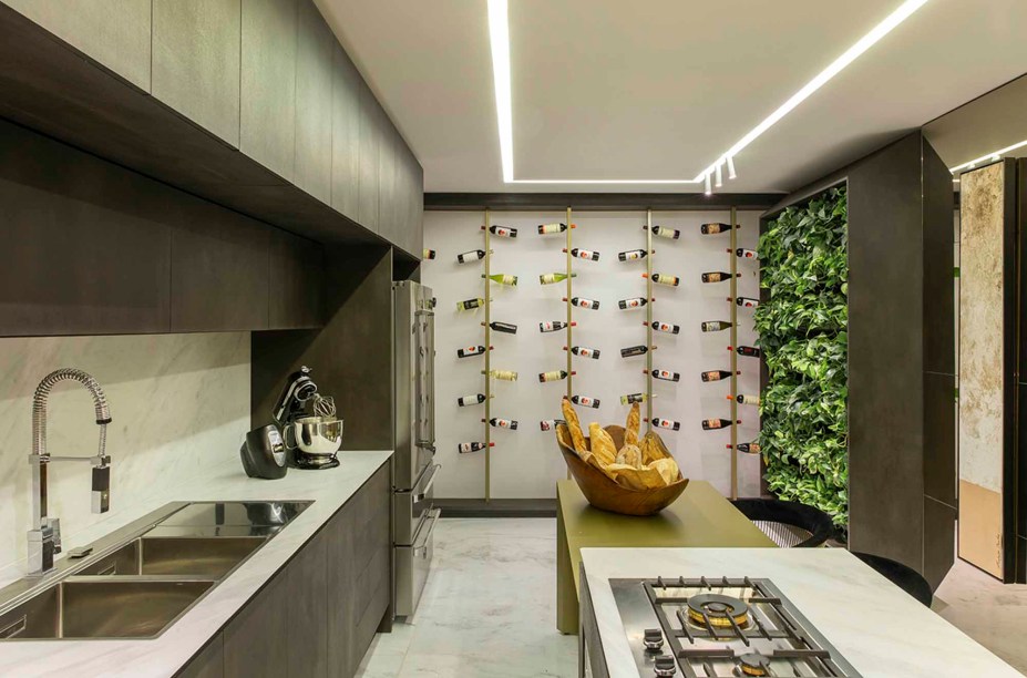CASACOR Espírito Santo 2019. Cozinha - Thainá Castro e Rhamires Recla. As referências são italianas nestes 25 m², que abrigam cores e objetos que remetem à culinária e às cores clássicas da moda do país europeu, como preto e dourado. O mármore surge no piso e na bancada da cozinha. A marcenaria clean e moderna garante o equilíbrio perfeito do mix de inspirações. Destaque para a adega com mais de 50 rótulos, com uma lona tensionada que a ilumina.