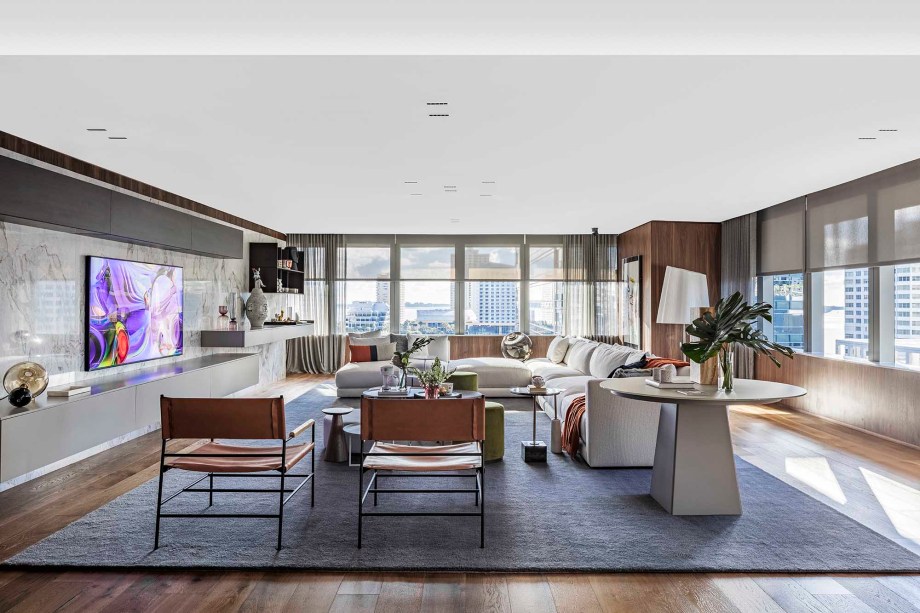 Family Room - Allan Malouf. O quarto elegante representa uma grande mudança em relação ao seu projeto de 2018 para a CASACOR Miami. "No ano passado, criamos um espaço muito colorido ”, diz Malouf. “Nosso projeto nesta temporada é sobre uma paleta de cores neutras. Os tons esbranquiçados, cinza claro e noz quente criam uma atmosfera acolhedora e sofisticada. O grande sofá em forma de L, bem no centro da sala, pode acomodar a família e convidados confortavelmente. Como uma lembrança de suas origens brasileiras, o designer de interiores selecionou materiais naturais da América do Sul. Eles aparecem no piso de madeira e nas estantes, bem como na pedra de mármore que emoldura a TV.