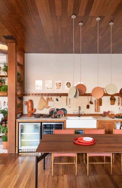 CASACOR Ribeirão Preto 2019. Cacau Ribeiro - Loft Essencial. Para a arquiteta Camila Ribeiro Cury, essencial é estar com a família. Por isso, ela imaginou esta área de convivência confortável e cheia de significados. Os caixilhos formam estantes e trazem tanto a luz natural como o jardim para o interior. A luminária é de Ingo Maurer, a poltrona tem desenho de Sergio Rodrigues e a mesa de centro, de Rodrigo Ohtake.