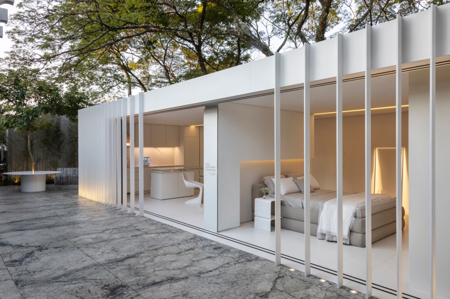 Casa Contêiner Cosentino - Marilia Pellegrini. Em seu projeto com bases sustentáveis e foco em reaproveitamento de materiais, dois contêineres foram acoplados para dar vida a uma casa de 60m², que conta com living, cozinha e lavanderia integrados, além de uma suíte com um banheiro incrivelmente confortável. Os ambientes foram tomados por tons de branco, clima minimalista e peças de grandes designers, como Oki Sato, que traz sofisticação surpreendente ao espaço. A casa contêiner conta ainda com uma área externa de 100m² com piso em Granito White Lava, uma horta hidropônica auto irrigável e um inconfundível jardim de bambus.