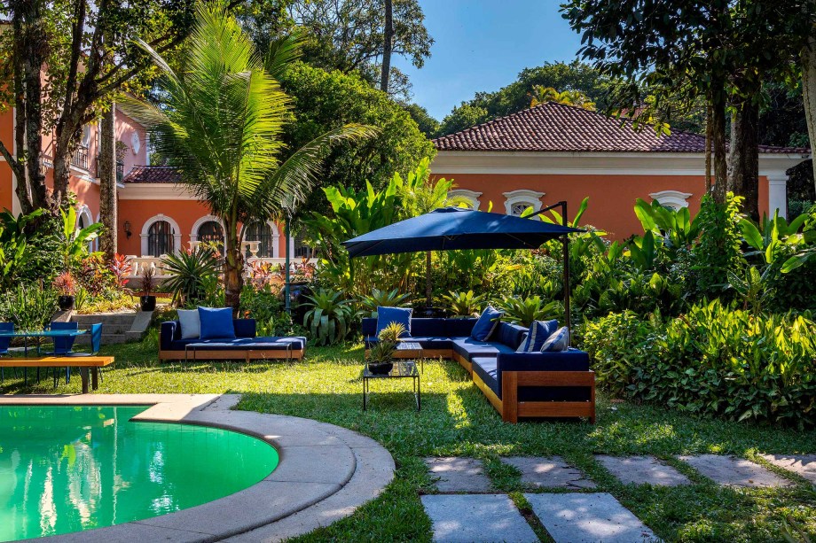 Café - Lucilla Pessoa de Queiroz e Renata Caiafa Quintanilha. CASACOR Rio de Janeiro 2021. Tomar um café à beira da piscina enquanto contempla a natureza é o objetivos deste espaço. No mobiliário, o ferro e a madeira predominam nas peças criadas pelas arquitetas para o ambiente. Mas há ainda móveis contemporâneos de área externa e criações de Sérgio Rodrigues.