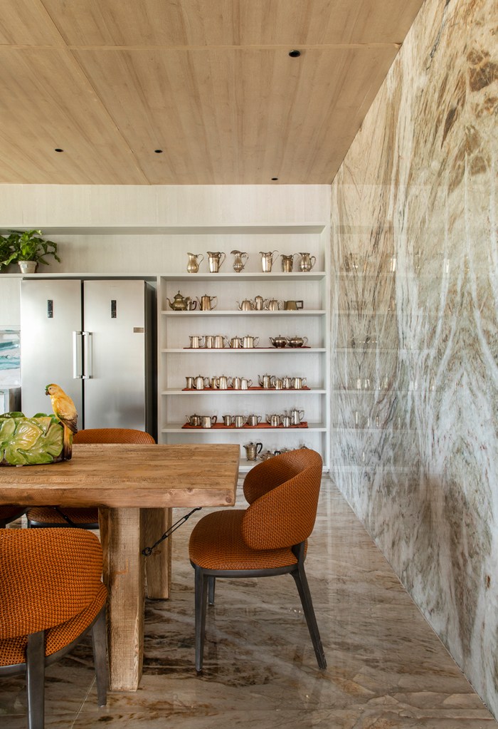 parede-quartzo-sala-de-jantar Parede e piso em quartzito claro com mesa de jantar na frente e prateleiras na lateral