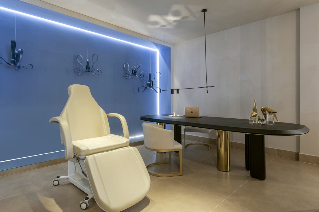 Elizabeth Pires e Déborah Meireles - Clínica de Estética. Neste espaço, elementos, tons, materiais e mobiliários acolhem o paciente para que ele se sinta em um espaço familiar e aconchegante. O visitante é atraído por um painel de pedra natural com metal dourado e, ao adentrar, é impactado pelo pé-direito alto e por fotografias de personagens femininas com fitas de iluminação de LED ao redor. Destaque para as oito flores esculturais flutuantes, penduradas por um cabo de aço. Elizabeth Pires e Déborah Meireles - Clínica de Estética. Neste espaço, elementos, tons, materiais e mobiliários acolhem o paciente para que ele se sinta em um espaço familiar e aconchegante. O visitante é atraído por um painel de pedra natural com metal dourado e, ao adentrar, é impactado pelo pé-direito alto e por fotografias de personagens femininas com fitas de iluminação de LED ao redor. Destaque para as oito flores esculturais flutuantes, penduradas por um cabo de aço.