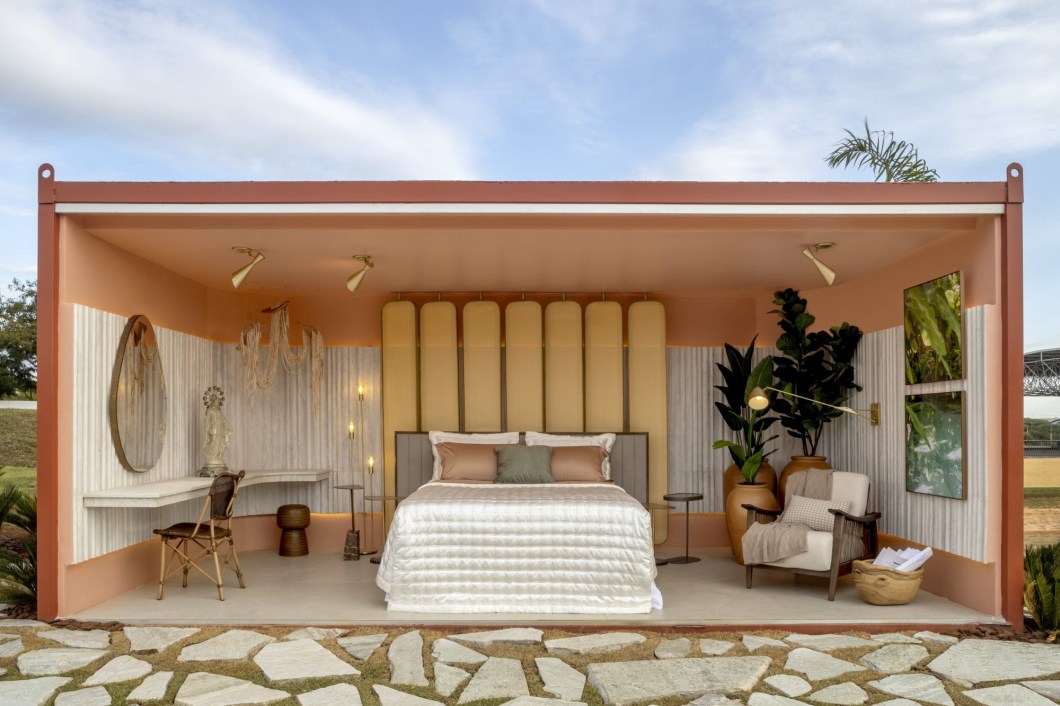 Kelly Iamamoto e Mariana Vinhal- Quarto Oasis. O pós-pandemia despertou a necessidade de se sentir acolhido, e essa é a inspiração do ambiente projetado pelas arquitetas Kelly Iamamoto e Mariana Vinhal. Acolhedor e multifuncional, o quarto foi pensado para proporcionar aconchego e funcionalidade ao mesmo tempo. No ambiente, os tons terrosos e nudes estão presentes em itens regionais como o barro e a palha e se integram com o verde da parte externa. O mobiliário é confortável, corroborando com o aconchego pretendido. A iluminação indireta tem pontos focais harmonizados com o conceito do ambiente. Kelly Iamamoto e Mariana Vinhal- Quarto Oasis. O pós-pandemia despertou a necessidade de se sentir acolhido, e essa é a inspiração do ambiente projetado pelas arquitetas Kelly Iamamoto e Mariana Vinhal. Acolhedor e multifuncional, o quarto foi pensado para proporcionar aconchego e funcionalidade ao mesmo tempo. No ambiente, os tons terrosos e nudes estão presentes em itens regionais como o barro e a palha e se integram com o verde da parte externa. O mobiliário é confortável, corroborando com o aconchego pretendido. A iluminação indireta tem pontos focais harmonizados com o conceito do ambiente.
