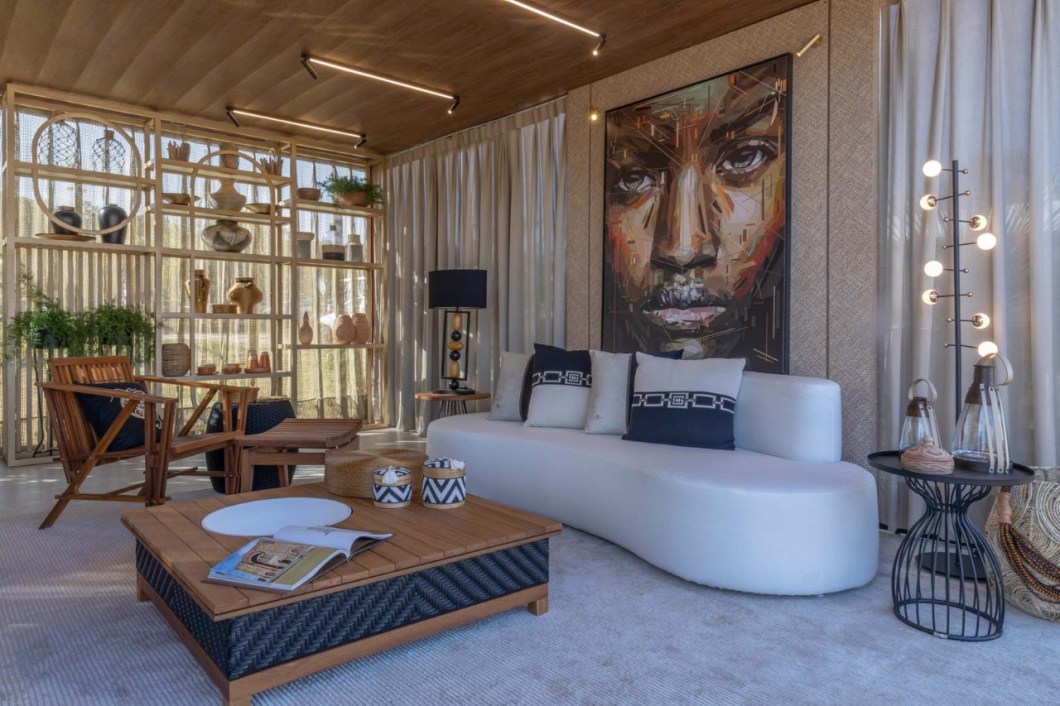 Cássia Veras e Bruno Freitas - Espaço Infinito Particular Sebrae. Todos nós temos algum ritual de aconchego, descanso e relaxamento quando chegamos em nossos lares, em nosso infinito particular. Pensando nisso, os arquitetos Cássia Veras e Bruno de Freitas criaram um ambiente que contempla sala de jantar e estar. Os tons naturais, encontrados na natureza, como bege, madeira, terracota trazem aconchego e estão presentes nos elementos de decoração e artesanato regional. Os pontos de cor ficam por conta de adornos e de uma obra de arte que remete à força do ser humano. Destaque para uma árvore que homenageia as mulheres fortes do Tocantins, na área externa do ambiente. Cássia Veras e Bruno Freitas - Espaço Infinito Particular Sebrae. Todos nós temos algum ritual de aconchego, descanso e relaxamento quando chegamos em nossos lares, em nosso infinito particular. Pensando nisso, os arquitetos Cássia Veras e Bruno de Freitas criaram um ambiente que contempla sala de jantar e estar. Os tons naturais, encontrados na natureza, como bege, madeira, terracota trazem aconchego e estão presentes nos elementos de decoração e artesanato regional. Os pontos de cor ficam por conta de adornos e de uma obra de arte que remete à força do ser humano. Destaque para uma árvore que homenageia as mulheres fortes do Tocantins, na área externa do ambiente.