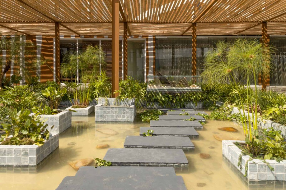 Shoraya Canêdo - Praça Externa. Para elaborar o Terraço Flamboyant, a paisagista Shoraya Canêdo criou uma conexão entre a natureza e o contemporâneo. O ambiente se constrói na ideia de que o visitante consiga viajar dentro de si, de seu mundo particular. Foram trabalhados no ambiente os quatro elementos: terra, água, fogo e ar. E dentre os elementos presentes, o espelho d’água foi criado em estilo único, permitindo que o visitante passe pelo fogo e adentre caminhando por cima das águas como se encontrasse o seu próprio eu. O Terraço Flamboyant irá proporcionar o despertar através dos quatro elementos vitais em forma de um recomeço.