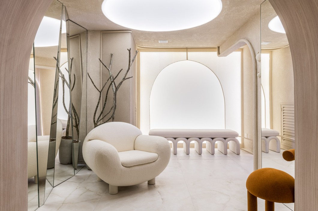 Carolina Scarpelli - Espaço Verso. Logo na entrada do banheiro unissex, a disposição dos espelhos produz o efeito de reflexos infinitos e permite que os visitantes percebam o espaço como um todo. O projeto de Carolina Scarpelli, que estreia na CASACOR, possibilita ainda a interação dos usuários com as imagens graças a uma tela que transmite informações e reage a estímulos. Ao mesmo tempo em que emprega tecnologia de ponta, o ambiente faz referência ao estilo greco-romano e sua ideia de triunfo por meio do uso de arcos. As formas arredondadas também aparecem na poltrona Madame, de Ricardo Van Steen. Carolina Scarpelli - Espaço Verso. Logo na entrada do banheiro unissex, a disposição dos espelhos produz o efeito de reflexos infinitos e permite que os visitantes percebam o espaço como um todo. O projeto de Carolina Scarpelli, que estreia na CASACOR, possibilita ainda a interação dos usuários com as imagens graças a uma tela que transmite informações e reage a estímulos. Ao mesmo tempo em que emprega tecnologia de ponta, o ambiente faz referência ao estilo greco-romano e sua ideia de triunfo por meio do uso de arcos. As formas arredondadas também aparecem na poltrona Madame, de Ricardo Van Steen.