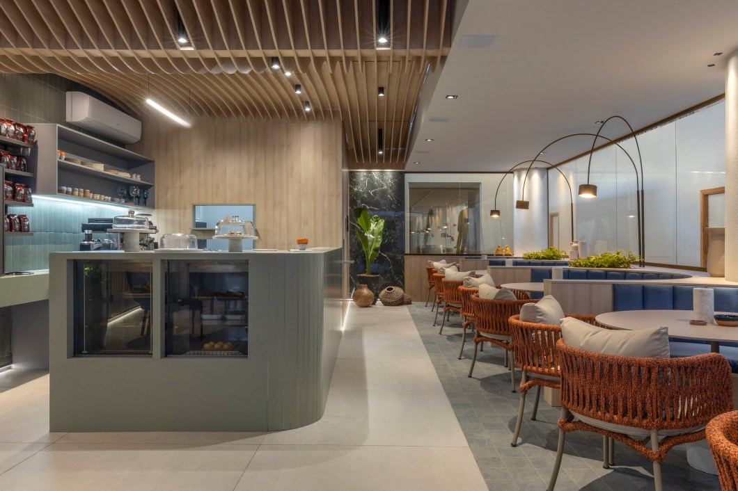 Lisi Sandri - Café. Com base no conceito de neuroarquitetura, Lisi Sandri utilizou-se do design biofílico, por meio das texturas, cores, formas, materiais e objetos, para projetar o Ambiente do Café, com 90,56 m². Com o requinte dos cafés especiais e o desafio de conectar o visitante ao ambiente, Lisi utilizou porcelanato, cores claras na madeira, bancadas em tons de verde para alinhar ao conceito de arquitetura orgânica, cerâmicas e pedras em formas de objetos de uso do café, muito presentes no projeto. Lisi Sandri - Café. Com base no conceito de neuroarquitetura, Lisi Sandri utilizou-se do design biofílico, por meio das texturas, cores, formas, materiais e objetos, para projetar o Ambiente do Café, com 90,56 m². Com o requinte dos cafés especiais e o desafio de conectar o visitante ao ambiente, Lisi utilizou porcelanato, cores claras na madeira, bancadas em tons de verde para alinhar ao conceito de arquitetura orgânica, cerâmicas e pedras em formas de objetos de uso do café, muito presentes no projeto.
