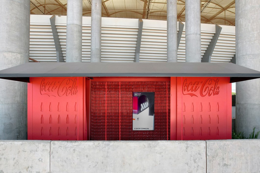 Renata Ciccarini - Coca-cola Experience. O ponto de partida do projeto foi a Coca-Cola Marshmello, criada com a colaboração do DJ americano Marshmello. O ambiente da arquiteta Renata Ciccarini, totalmente na cor vermelha, do piso ao teto, apresenta atmosfera de balada com a utilização de neon e laser. Por ser um módulo construtivo, provoca a sensação do visitante estar em uma caixa e o convida a uma experiência que visa ativar os cinco sentidos: o tato, por meio das texturas; o olfato pela essência contida no espaço; a visão, com as luzes e as imagens emitidas pela TV; a audição, provocada pelo som ambiente e o paladar, despertado com o sabor do novo refrigerante sem-açúcar e com sabor morango. Renata Ciccarini - Coca-cola Experience. O ponto de partida do projeto foi a Coca-Cola Marshmello, criada com a colaboração do DJ americano Marshmello. O ambiente da arquiteta Renata Ciccarini, totalmente na cor vermelha, do piso ao teto, apresenta atmosfera de balada com a utilização de neon e laser. Por ser um módulo construtivo, provoca a sensação do visitante estar em uma caixa e o convida a uma experiência que visa ativar os cinco sentidos: o tato, por meio das texturas; o olfato pela essência contida no espaço; a visão, com as luzes e as imagens emitidas pela TV; a audição, provocada pelo som ambiente e o paladar, despertado com o sabor do novo refrigerante sem-açúcar e com sabor morango.